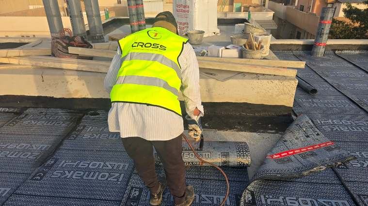 Crew installing roof membrane, First Mile