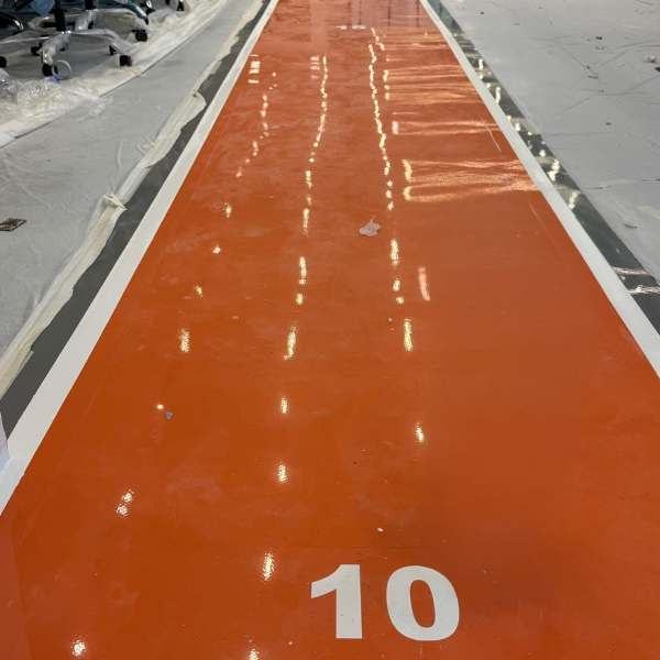 Orange epoxy running track with lane numbers